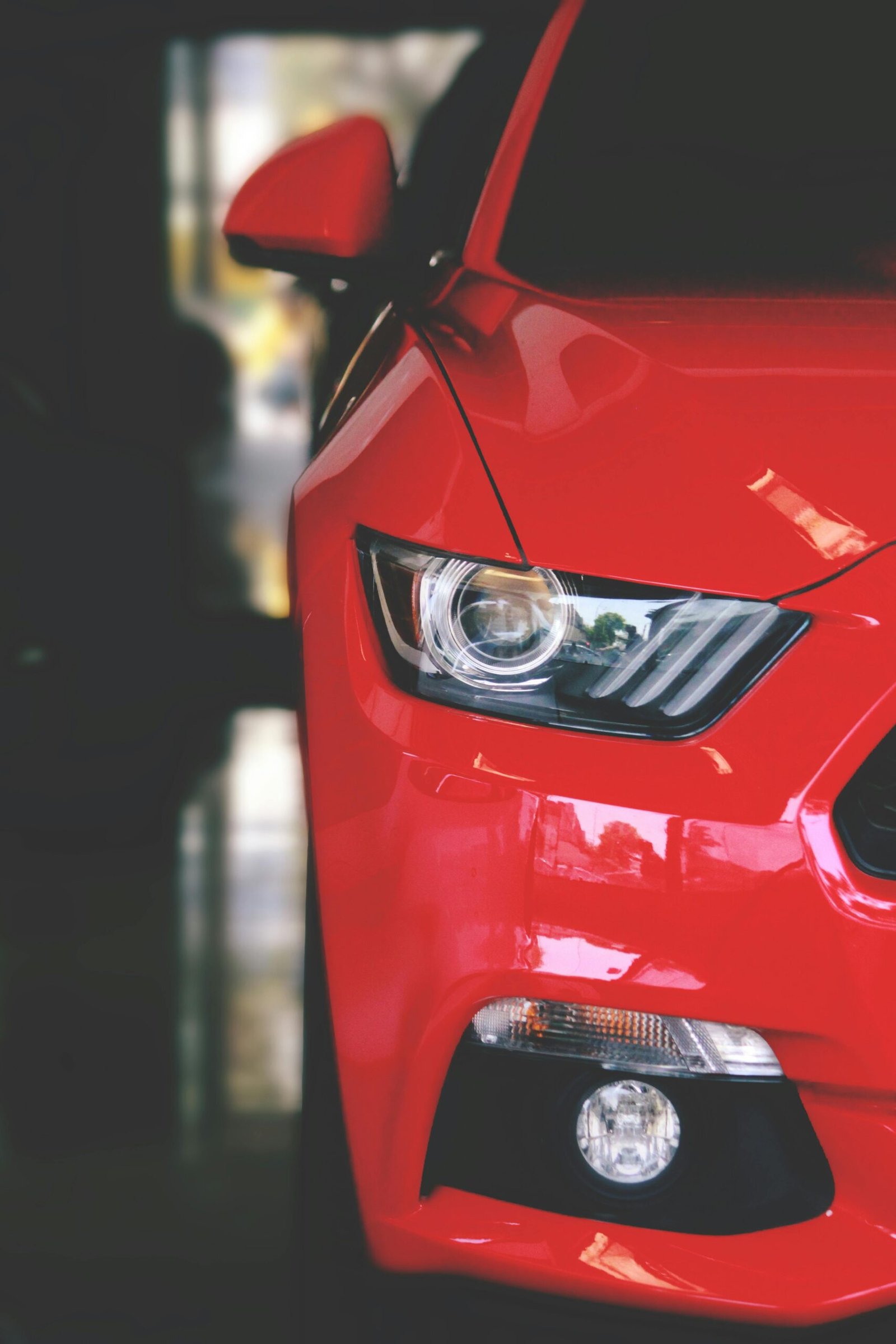 Detailed view of a sleek red sportscar showcasing elegant design and modern headlights.